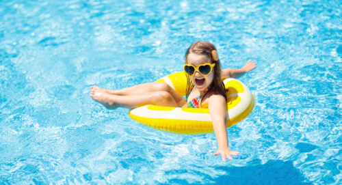 Child in swimming pool on ring toy
